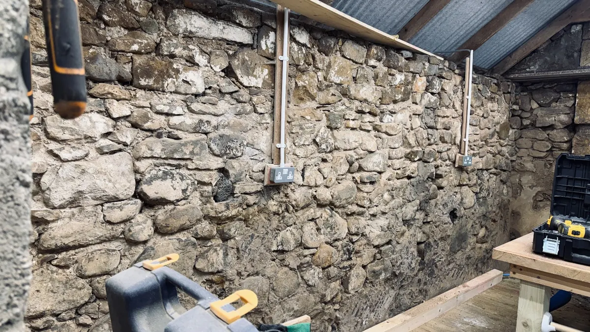 The rough stone wall inside, with new electrics going in