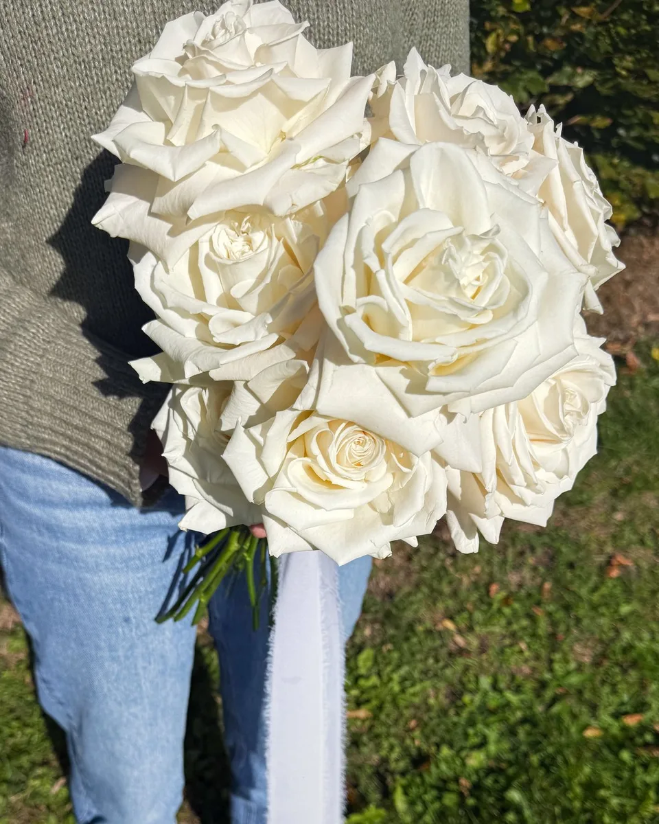 Bridal bouquet of large ivory garden roses tied with a long silk ribbon